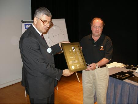 Alexander Soifer (USA) receives his Paul Erdös Award from WFNMC President Petar Kenderov, Cambridge 2004.